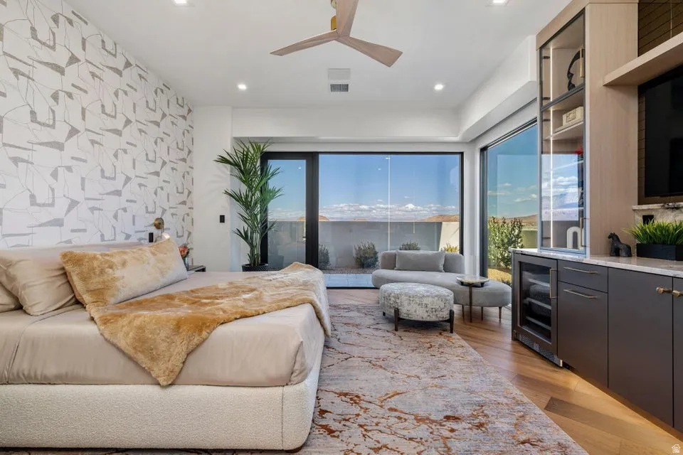 Spacious room featuring wood-finish flooring, a wall of glass sliding doors, and a built-in media center with a beverage refrigerator