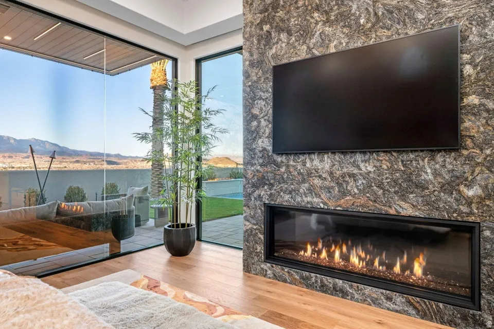 Contemporary living space featuring a floor-to-ceiling stone accent wall with an integrated linear fireplace