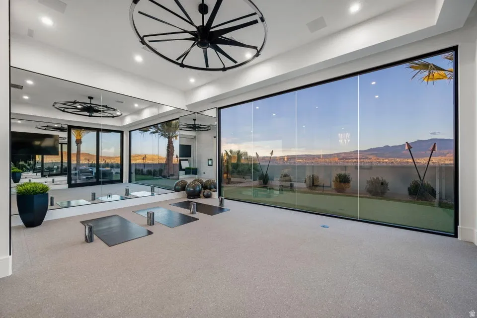 Interior space featuring floor-to-ceiling glass paneling, full-wall mirrors, and recessed lighting