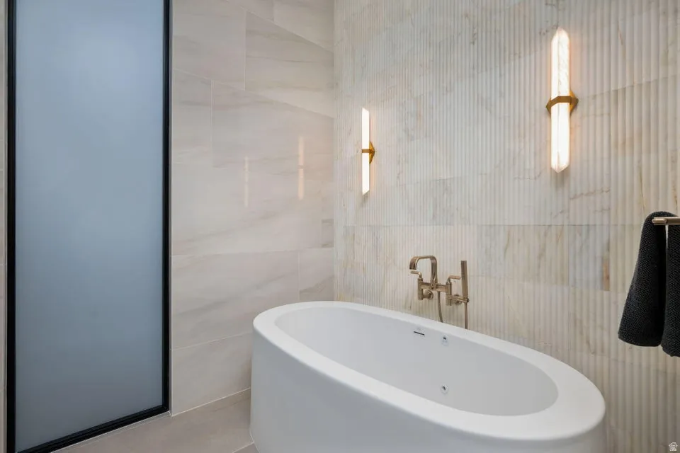 Freestanding oval soaking tub with wall-mounted bronze-finish faucet