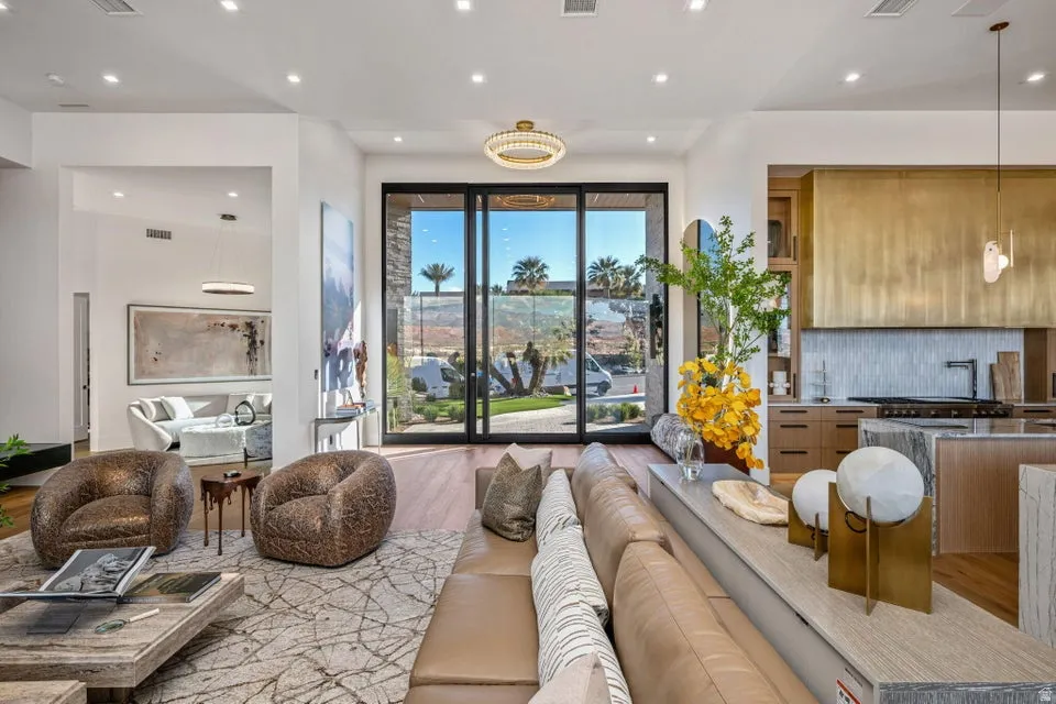Expansive living area with large format sliding glass doors, recessed lighting, and wood-finish flooring