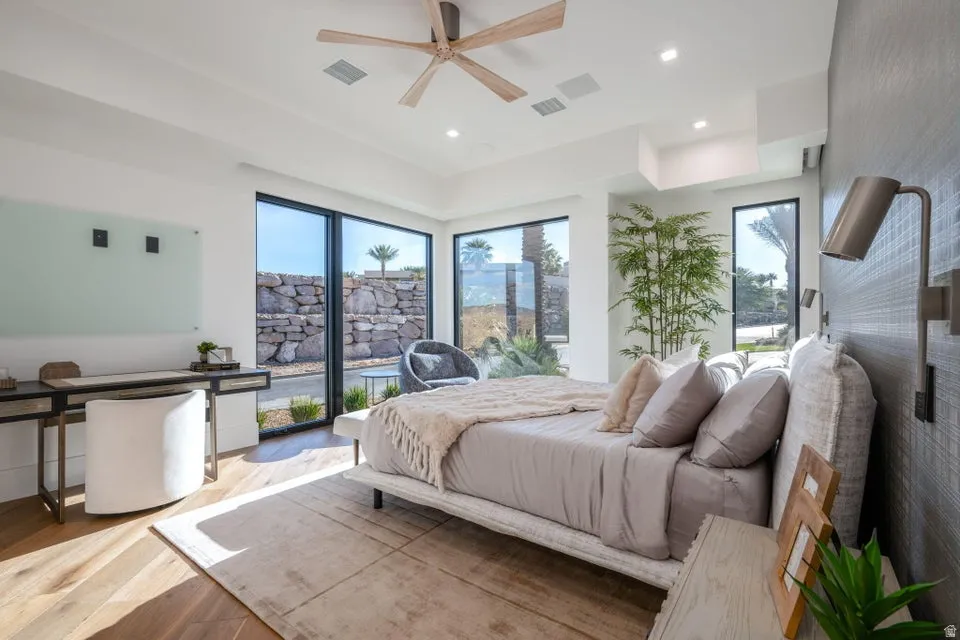 Bedroom featuring wide plank wood-finish flooring, a contemporary ceiling fan, recessed lighting, and expansive windows