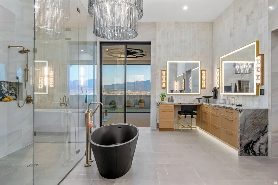 Contemporary bathroom featuring a freestanding black soaking tub, a spacious glass-enclosed shower with a rainfall showerhead, and dual vanities with illuminated mirrors