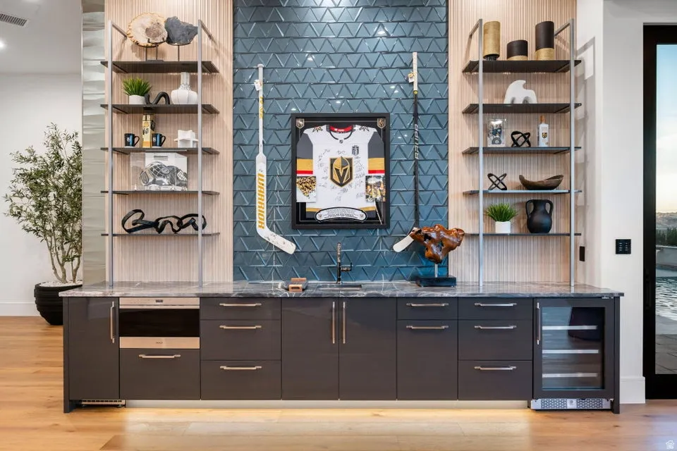 Contemporary wet bar featuring a geometric blue tile backsplash and light wood paneling