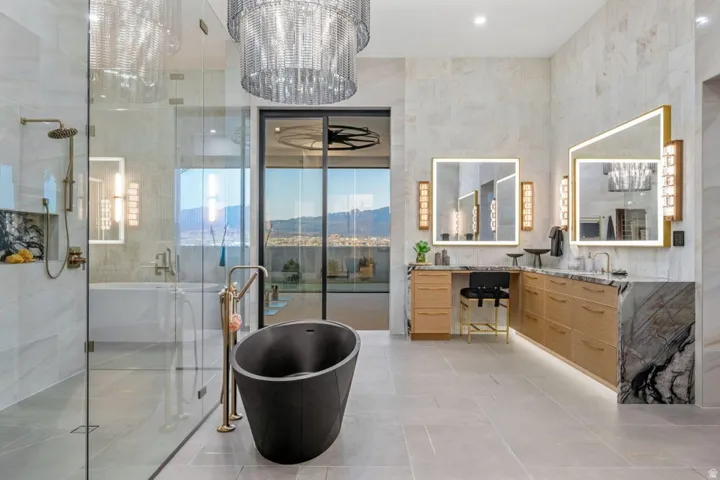 Contemporary bathroom featuring a freestanding black soaking tub, a spacious glass-enclosed shower with a rainfall showerhead, and dual vanities with illuminated mirrors