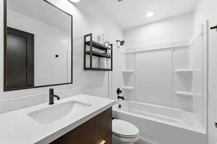 Bathroom featuring a dark wood-finish vanity with a light-toned countertop and integrated sink