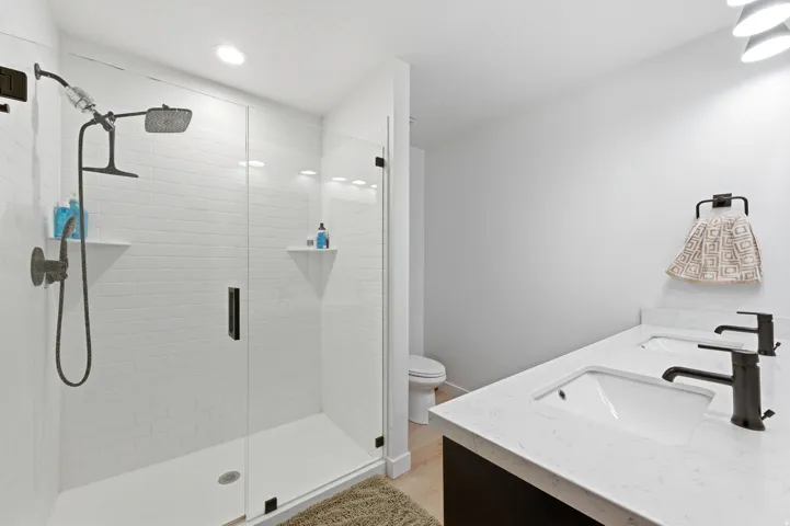 Modern bathroom featuring a double vanity with integrated sinks and black fixtures