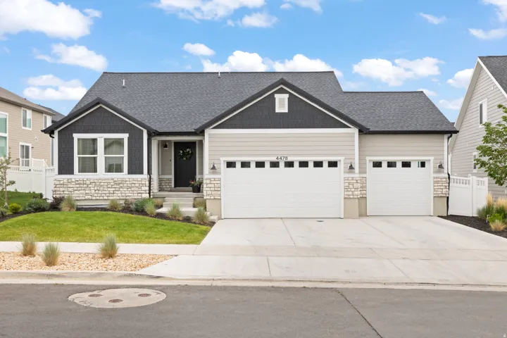 Modern exterior featuring a dark gray composite shingle roof, light gray siding, dark gray shake siding accents, and stone veneer detailing