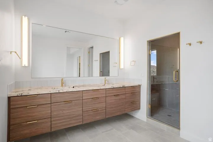 Floating wood-finish vanity with dual undermount sinks and a stone countertop
