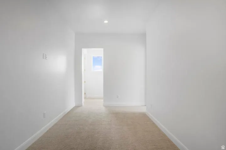 Neutral tone carpet flooring with white baseboards