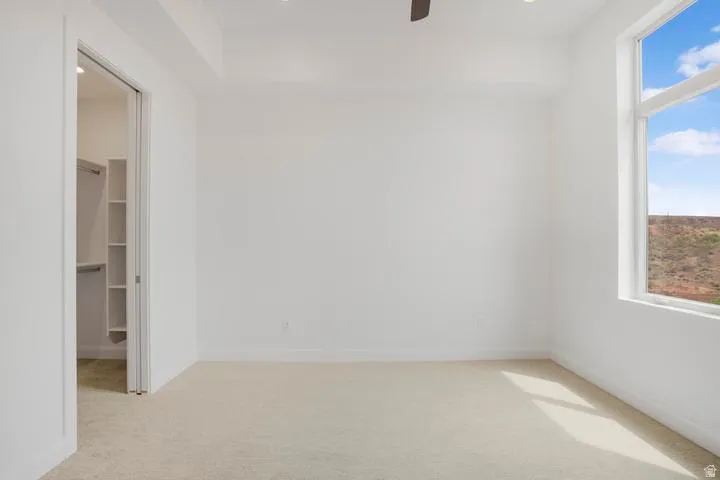 Open room with light beige carpeting and white walls