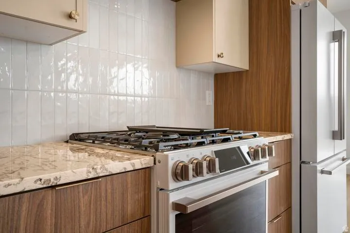 Stainless steel gas range with a griddle, complemented by light-toned stone countertops
