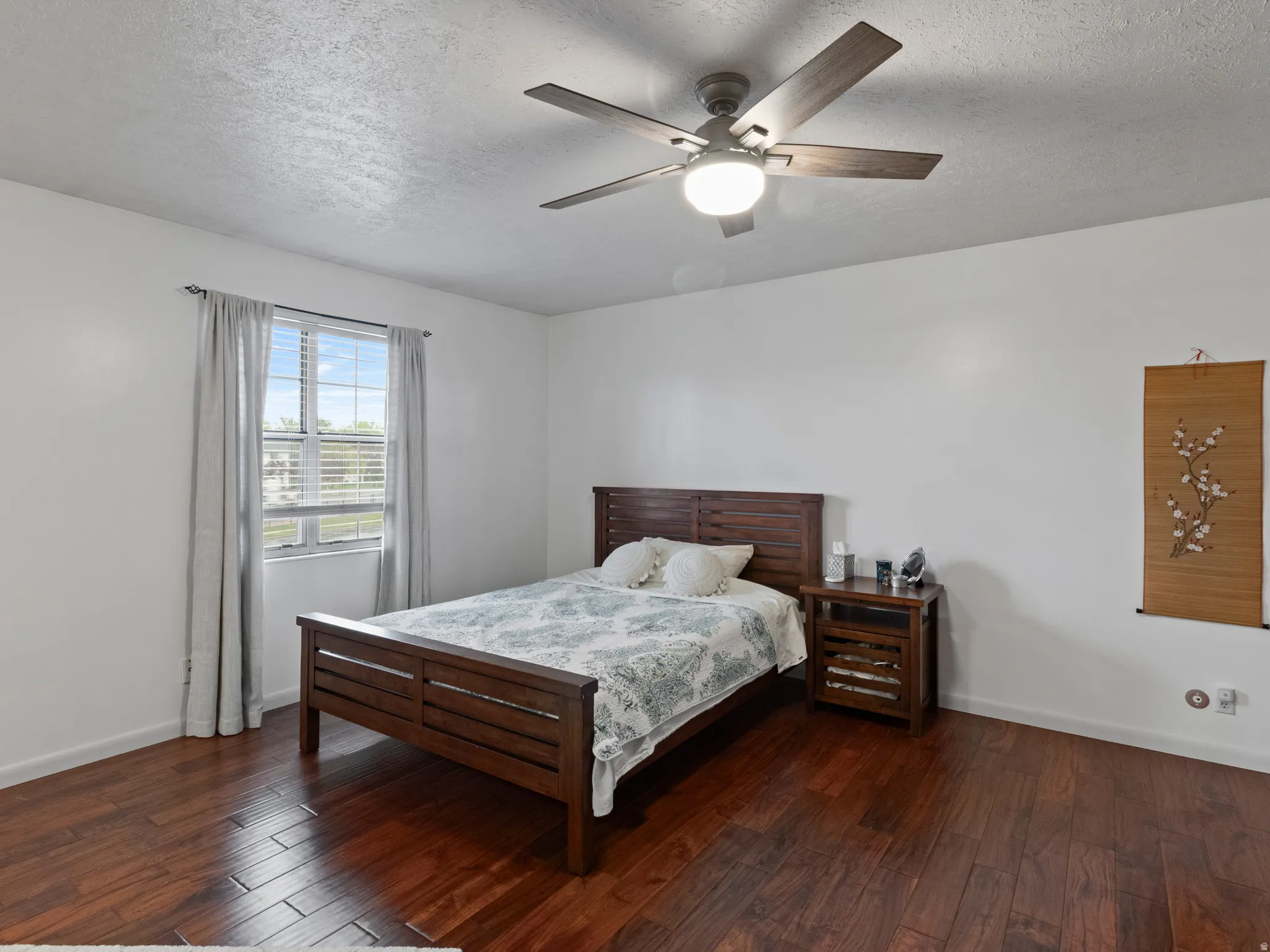 Bright room featuring wood-finish flooring, a window with horizontal blinds, and a ceiling fan with integrated lighting