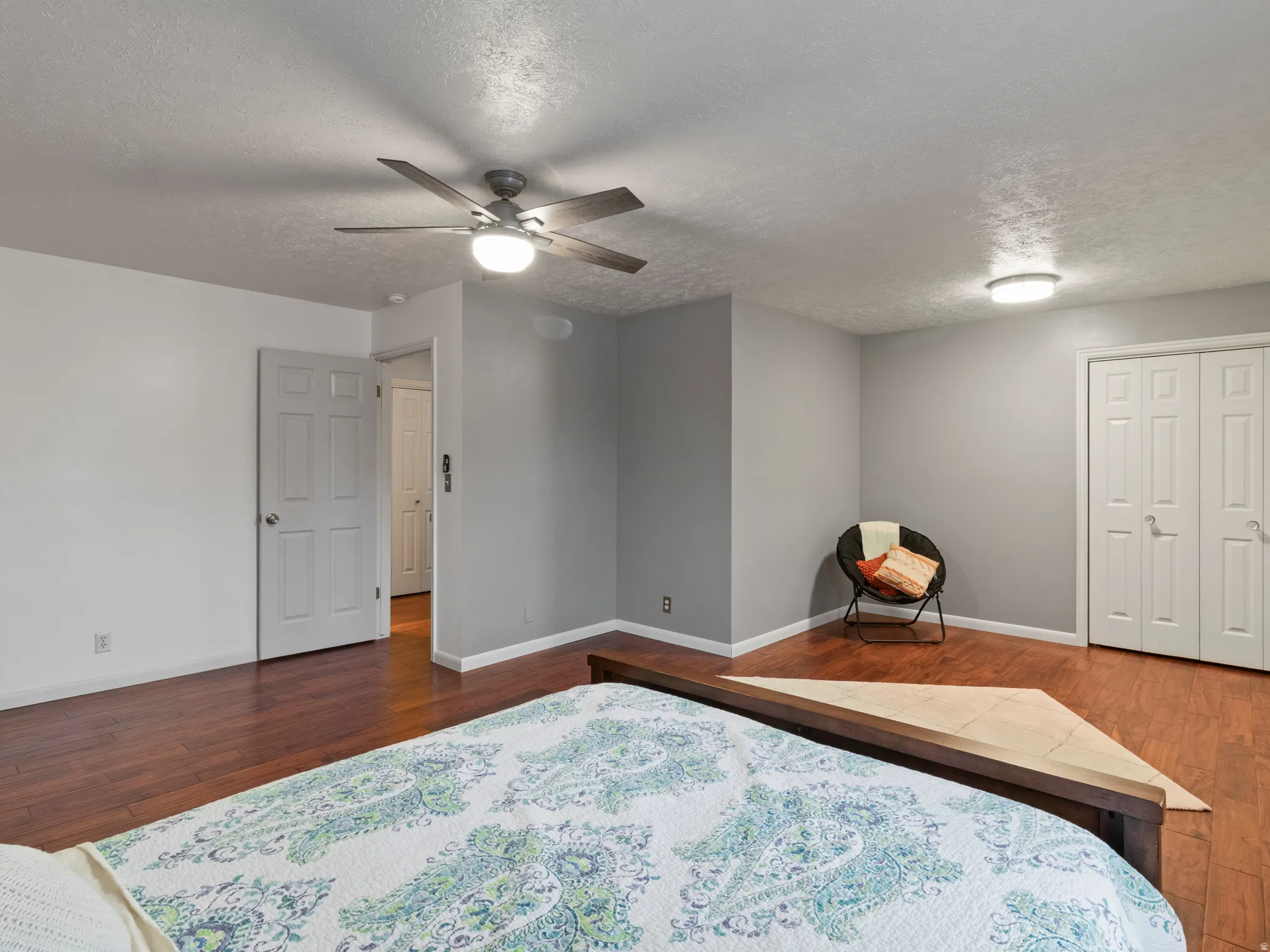 Spacious room featuring wood-finish flooring, light grey wall paint, and white trim