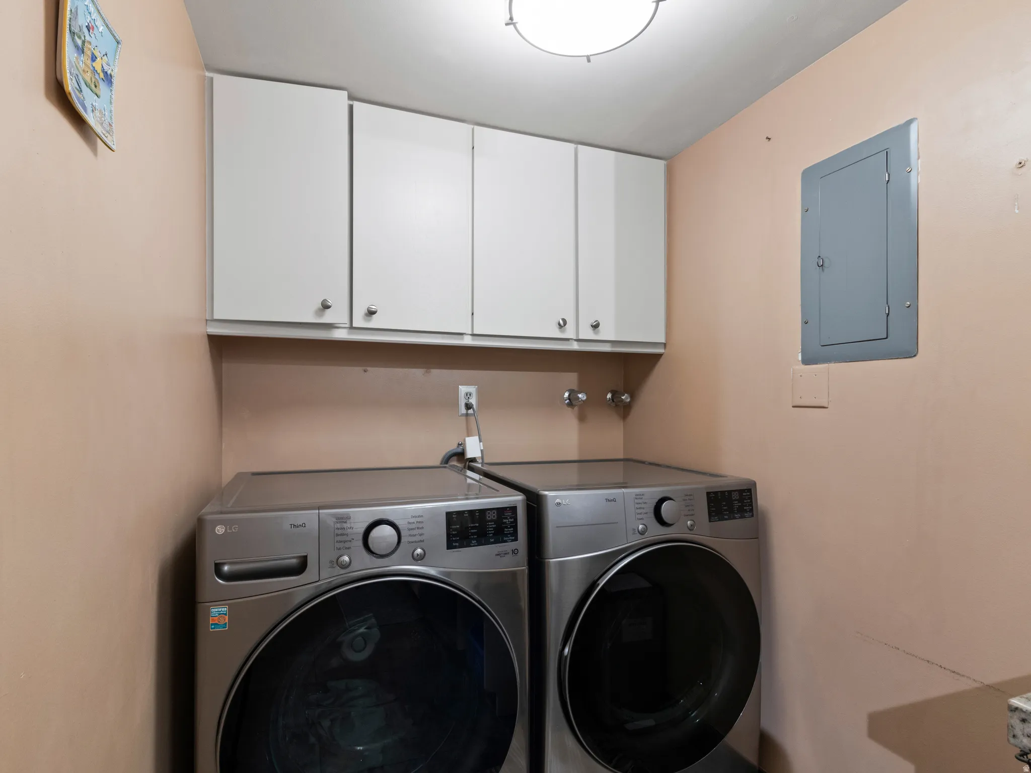 Dedicated laundry space featuring upper cabinetry storage