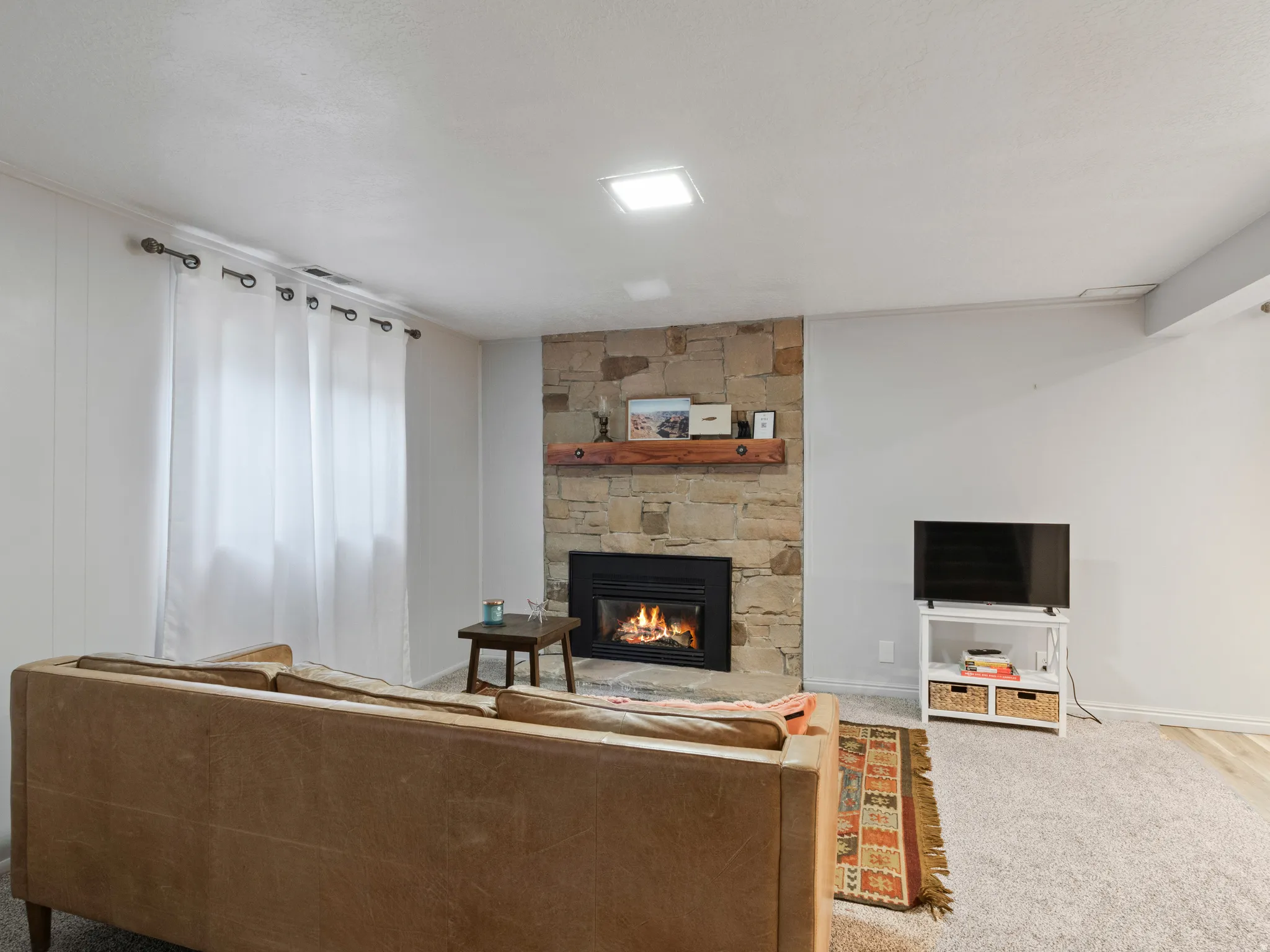 Stone-clad fireplace with a wood mantel