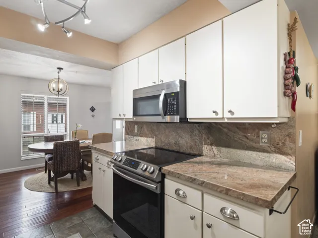 Kitchen featuring white cabinetry, stainless steel appliances, Granite countertops, and a matching  backsplash