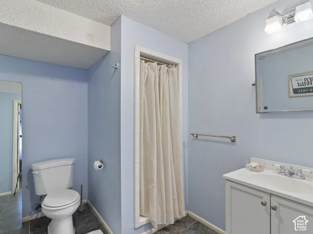 3/4 Bathroom featuring a white vanity with integrated sink, chrome hardware, and wall-mounted mirror with overhead lighting