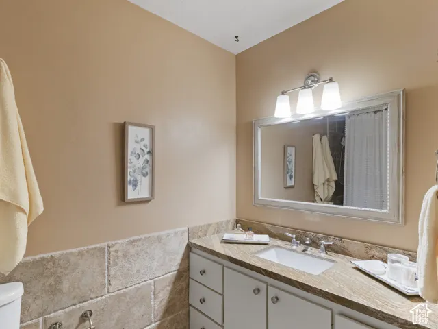 Master Bathroom featuring a white vanity with panel cabinetry, an undermount sink, and a granite countertop