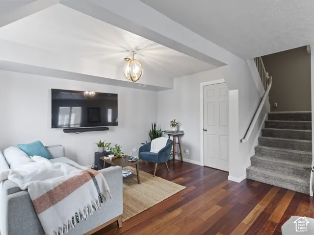 Hardwood-finish flooring anchors this living space, featuring a staircase to the second floor