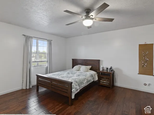 Bright room featuring wood-finish flooring, a window with horizontal blinds, and a ceiling fan with integrated lighting