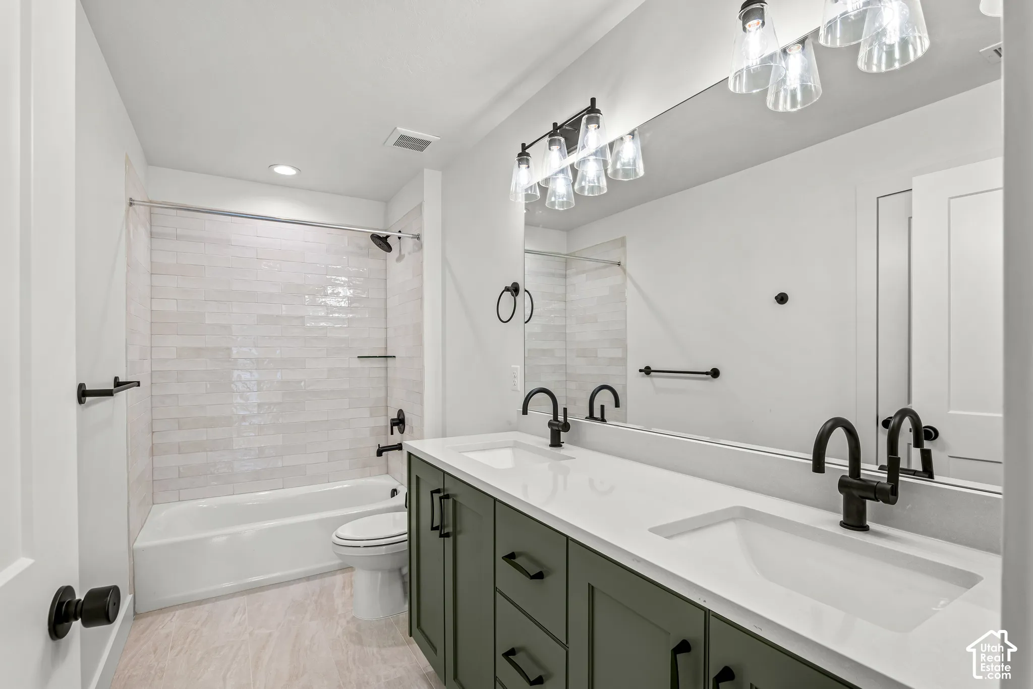Bathroom featuring a dual vanity with a white countertop and dark green cabinetry