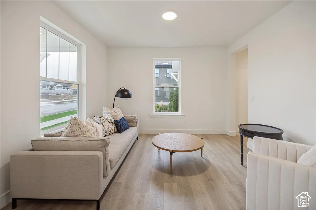 Neutral interior space featuring wood-finish flooring, dual windows, and a ceiling-mounted light fixture