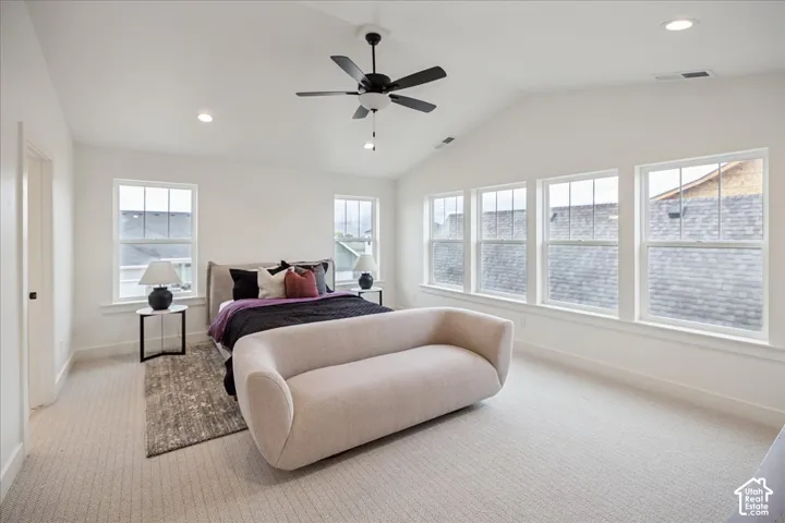 Primary Suite! Vaulted ceiling featuring a central matte black finish ceiling fan, abundant natural light from multiple windows, and neutral carpeting