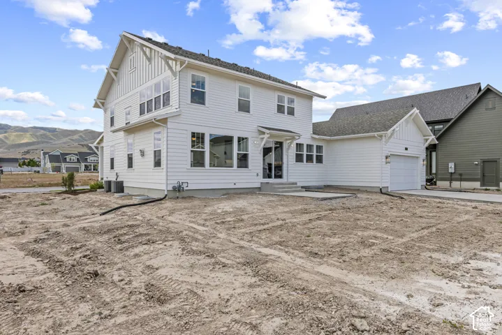 White two-story residence featuring board and batten siding accents and a contrasting dark gray shingle roof