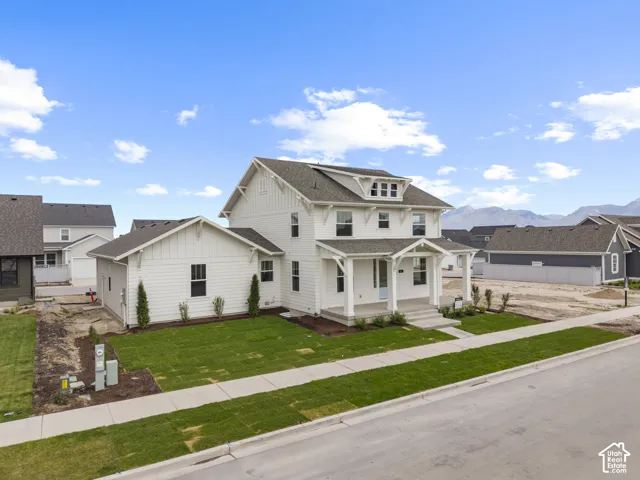 White two-story residence with dark grey roofing and dormer windows