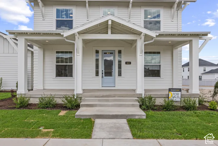 White clapboard siding exterior featuring a covered front porch with substantial columns