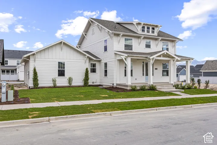 Contemporary farmhouse-style exterior featuring white horizontal siding and a covered front porch