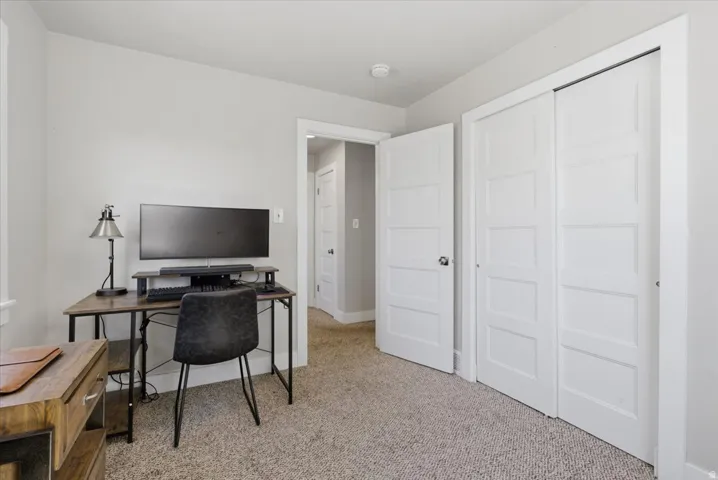Room featuring light gray walls, neutral carpet, and white five-panel interior doors