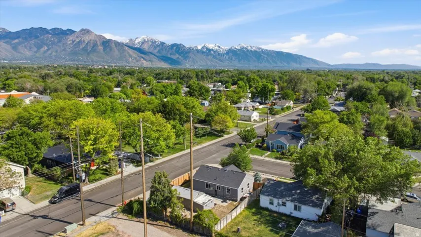 Residential neighborhood featuring mature trees and mountain ranges in the distance