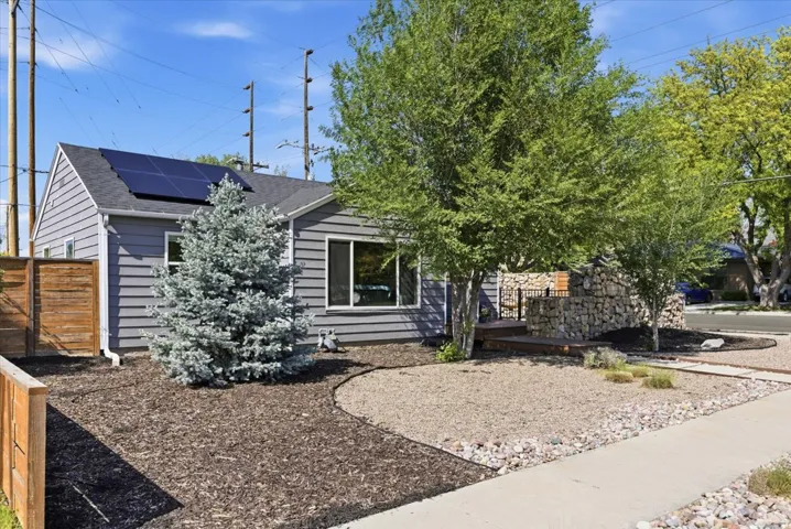 Gray siding exterior with solar panels and a pitched roof