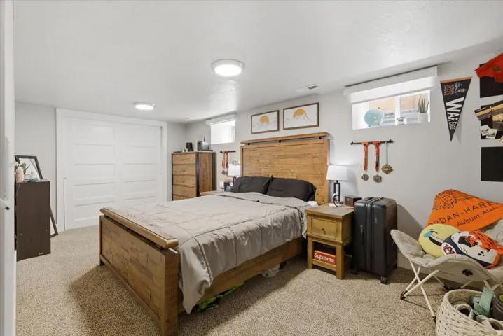 Carpeted bedroom featuring white walls, recessed lighting, and a window with a white blind