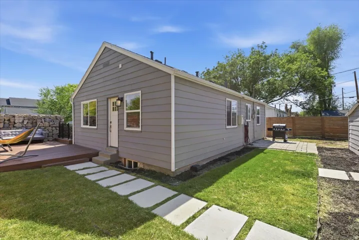 Rear exterior featuring gray horizontal siding and a white trim
