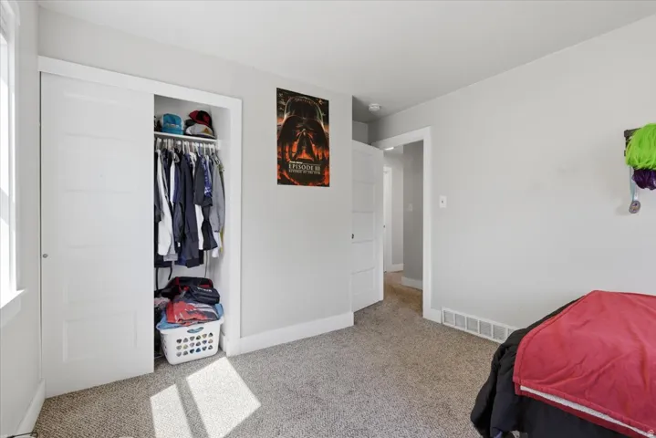 Bedroom featuring light gray walls, white trim, and light-toned carpeting