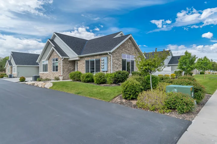 Stone and siding exterior with a dark shingle roof