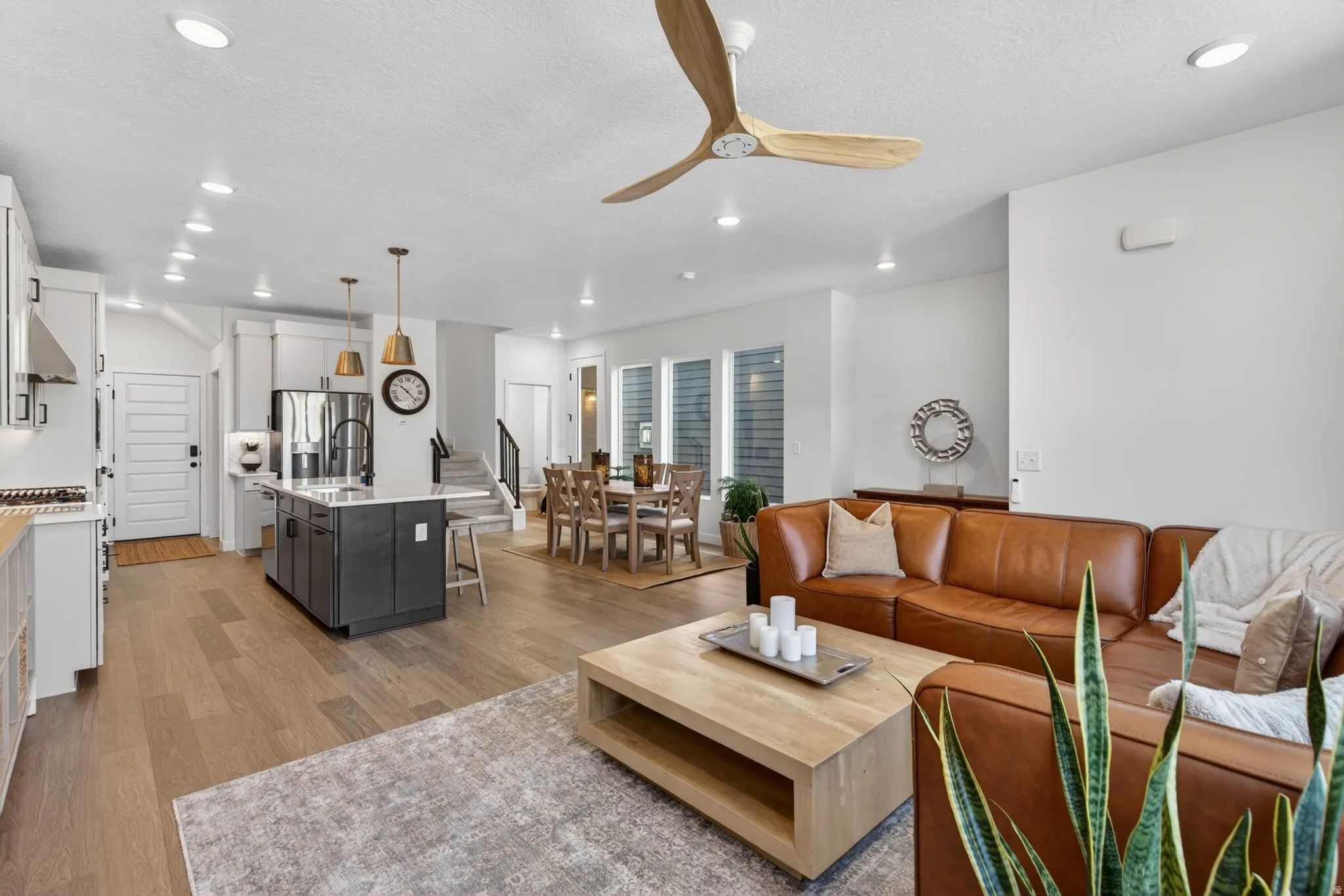 Open-concept living space featuring wood-finish flooring, recessed lighting, and a modern ceiling fan