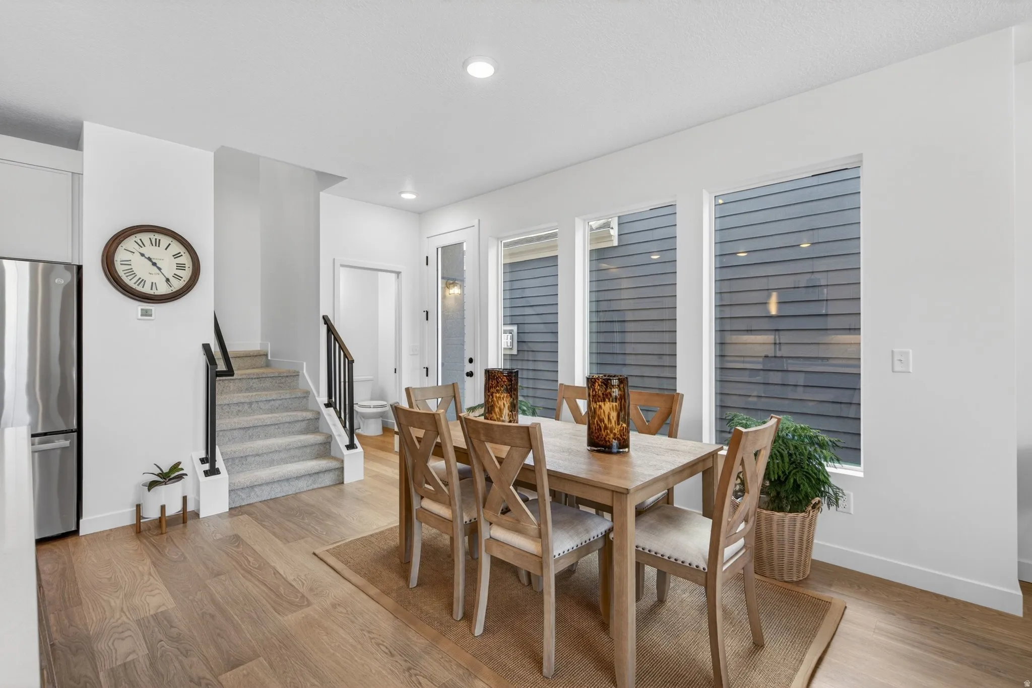 Open-concept dining area featuring wood-finish flooring, recessed lighting, and multiple windows