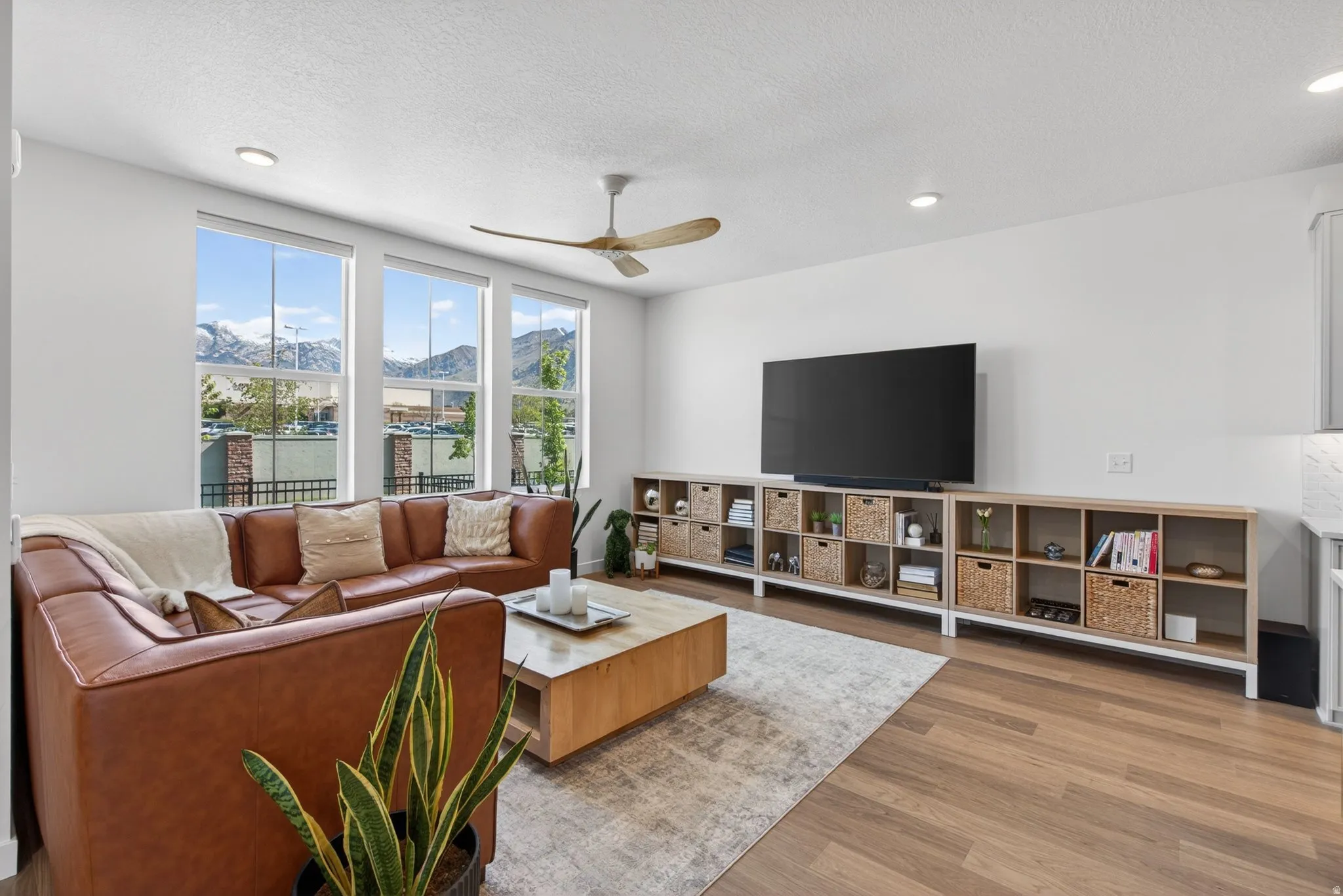 Living area with three large windows providing abundant natural light and mountain scenery