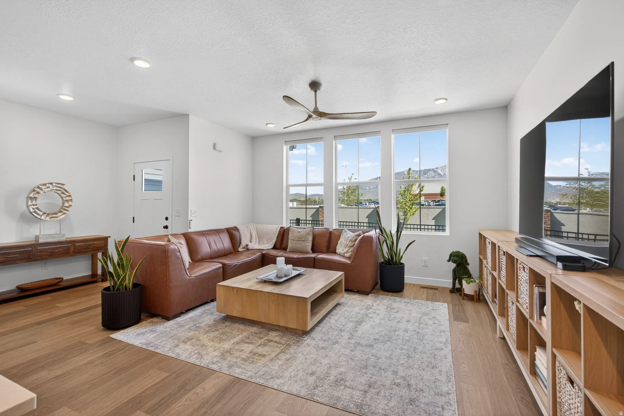 Spacious living area featuring large windows, recessed lighting, and wood-finish flooring