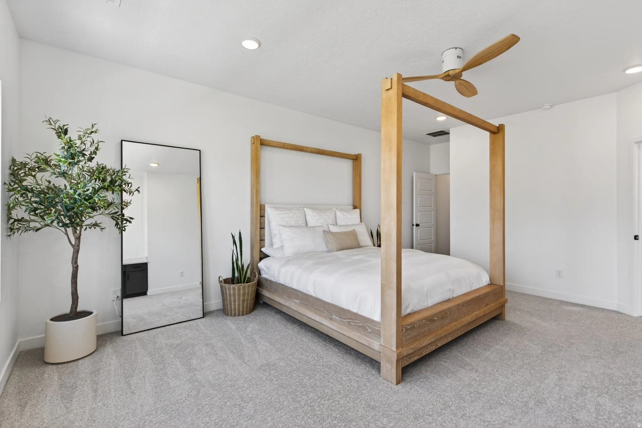 Spacious carpeted room featuring a ceiling fan with wood-finish blades, recessed lighting, and white walls