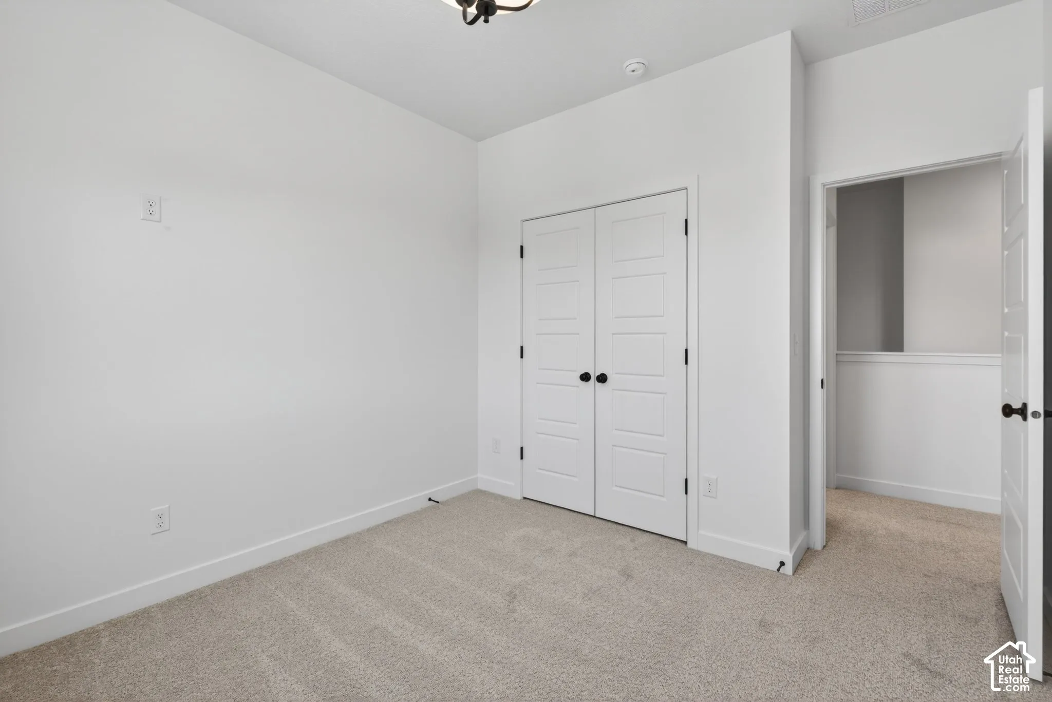 Carpeted room featuring white walls, white trim, and a ceiling-mounted light fixture