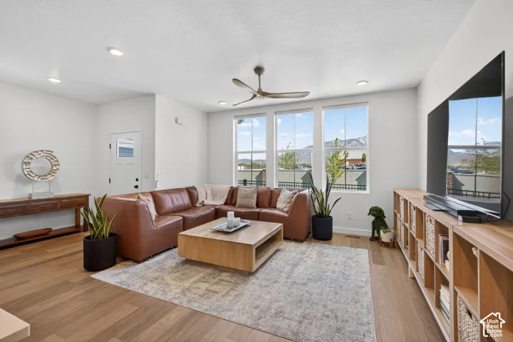 Spacious living area featuring large windows, recessed lighting, and wood-finish flooring