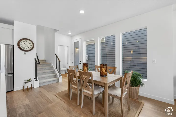 Open-concept dining area featuring wood-finish flooring, recessed lighting, and multiple windows