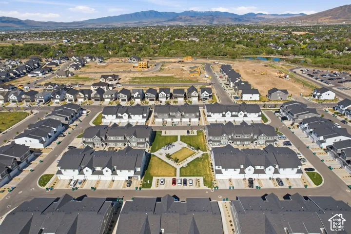 Aerial perspective of a developed community featuring various residential buildings with dark roofs and light-colored siding