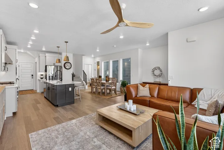 Open-concept living space featuring wood-finish flooring, recessed lighting, and a modern ceiling fan