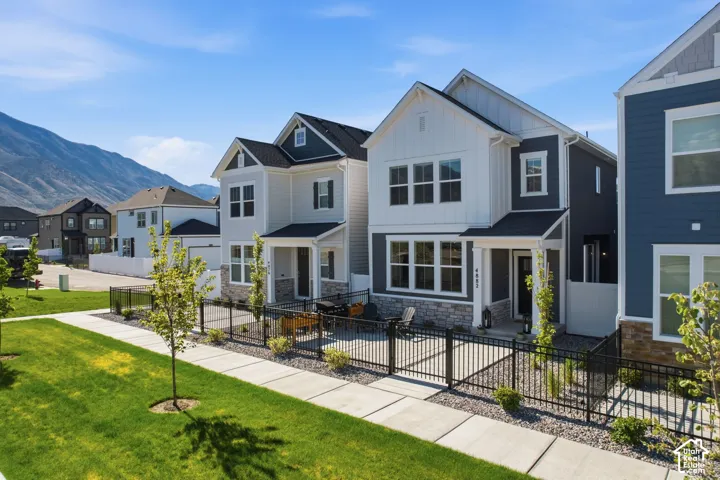 Contemporary two-story home featuring a combination of horizontal and vertical siding, stone accents, and a covered front porch